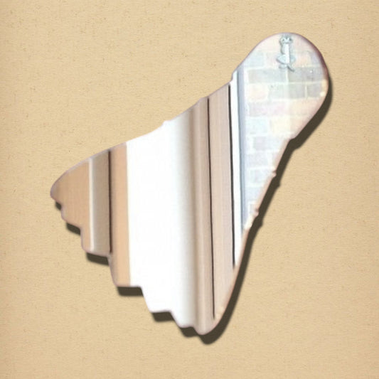 Shuttlecock-shaped mirror with a reflective surface, presented on a textured beige background.