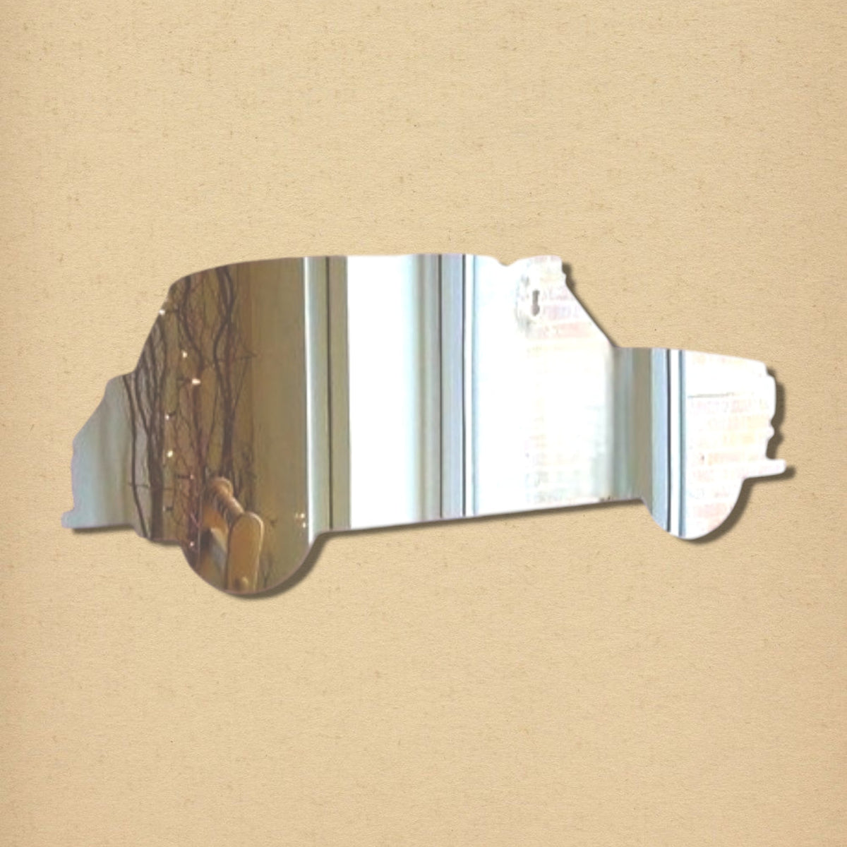 Taxi cab-shaped silver reflective mirror on a tan background.