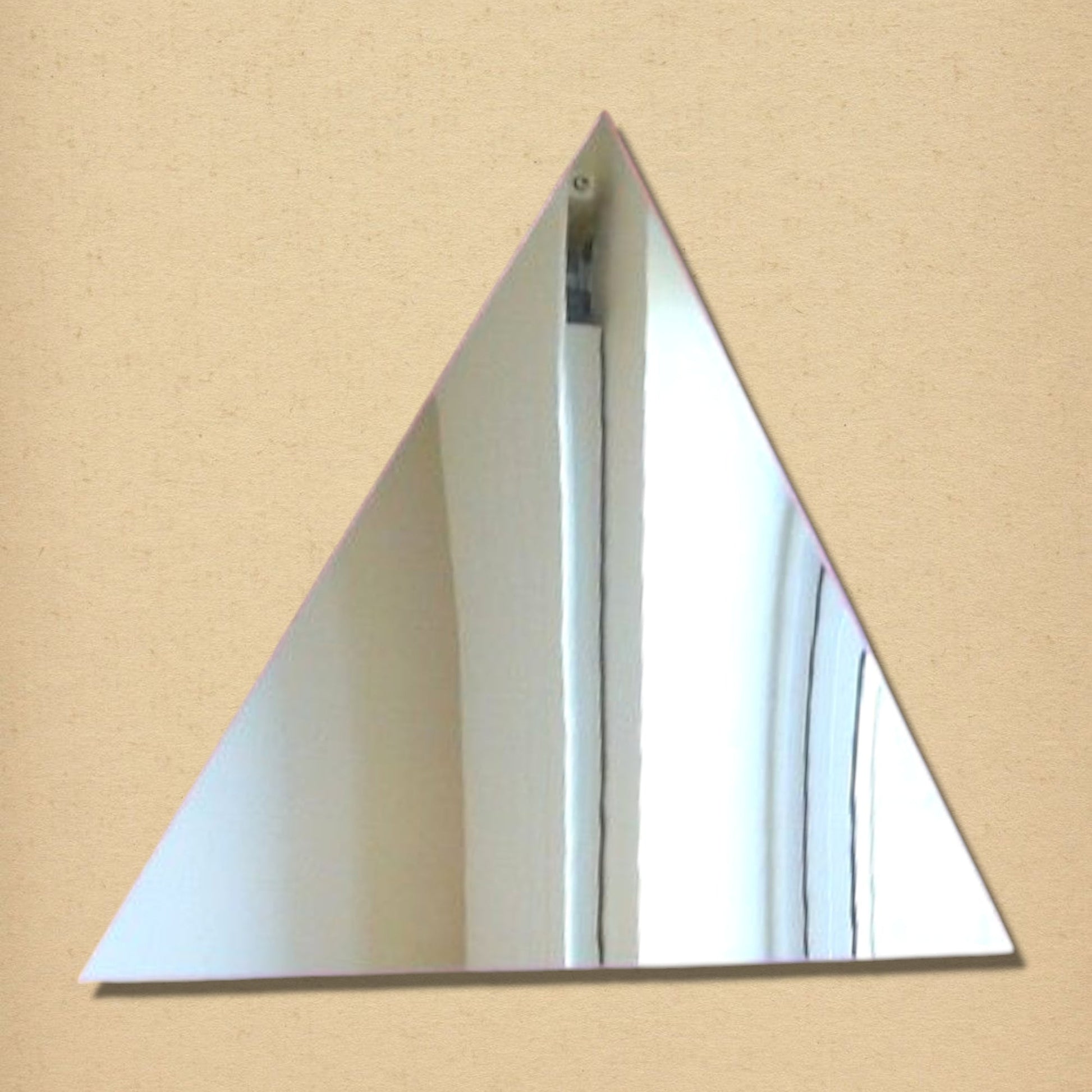 A triangular wall mirror with a simple frameless design.