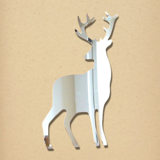 Stag-shaped silver acrylic wall mirror against a light brown background.