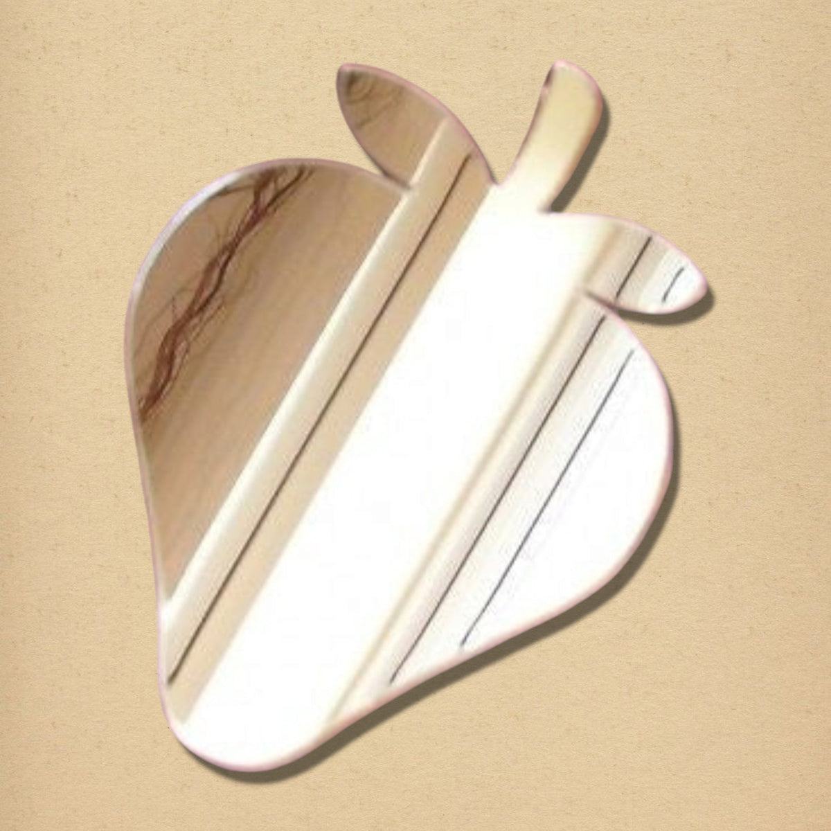 Strawberry-shaped mirror with a pink border, reflecting a light-colored wooden wall.