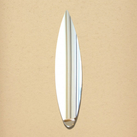 A surfboard-shaped mirror centered on a textured beige wall.