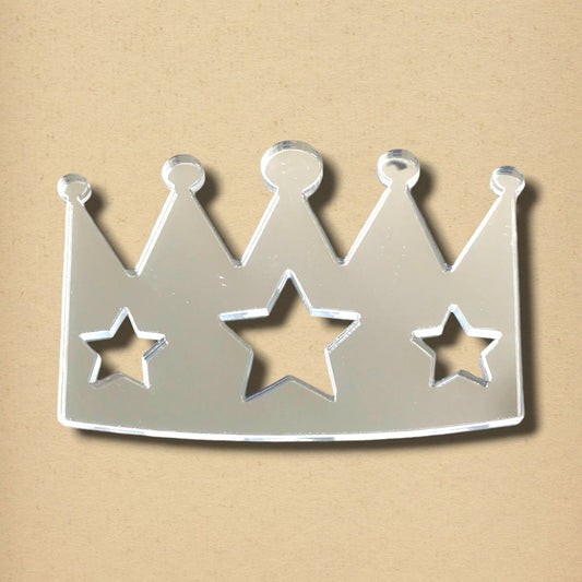 Crown-shaped mirror with three star cutouts, featuring a reflective surface against a beige background.