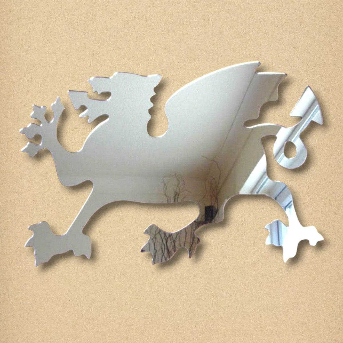 Silver Welsh dragon-shaped mirror on a light tan background.