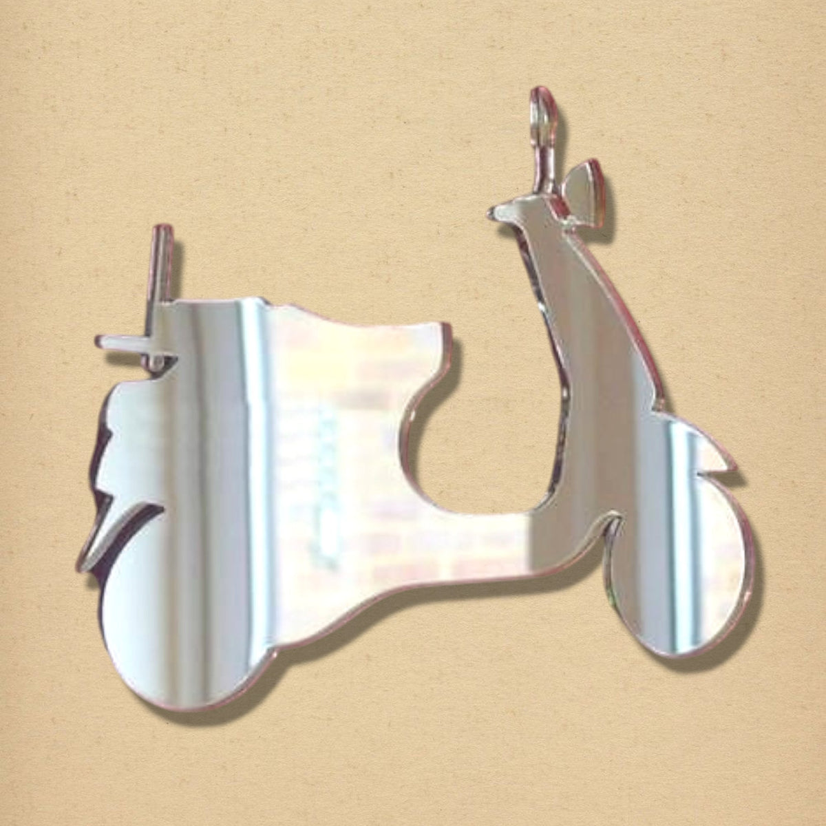 Moped scooter-shaped reflective mirror with a silver finish against a neutral beige background.