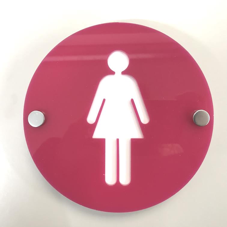 Round pink female toilet sign with a white silhouette and two metal standoffs.