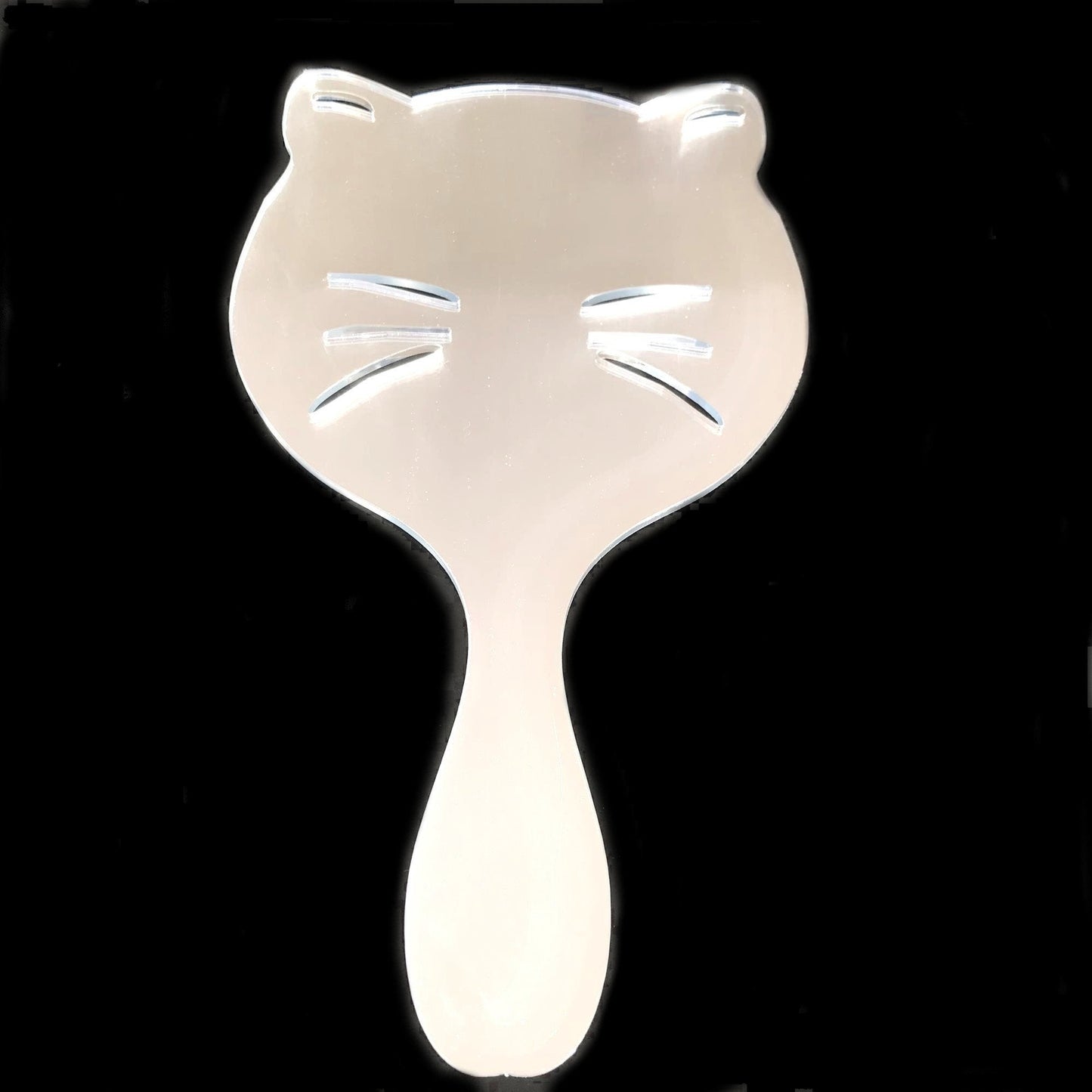 Cat shaped hand held mirror with etched whiskers, set against a black background.