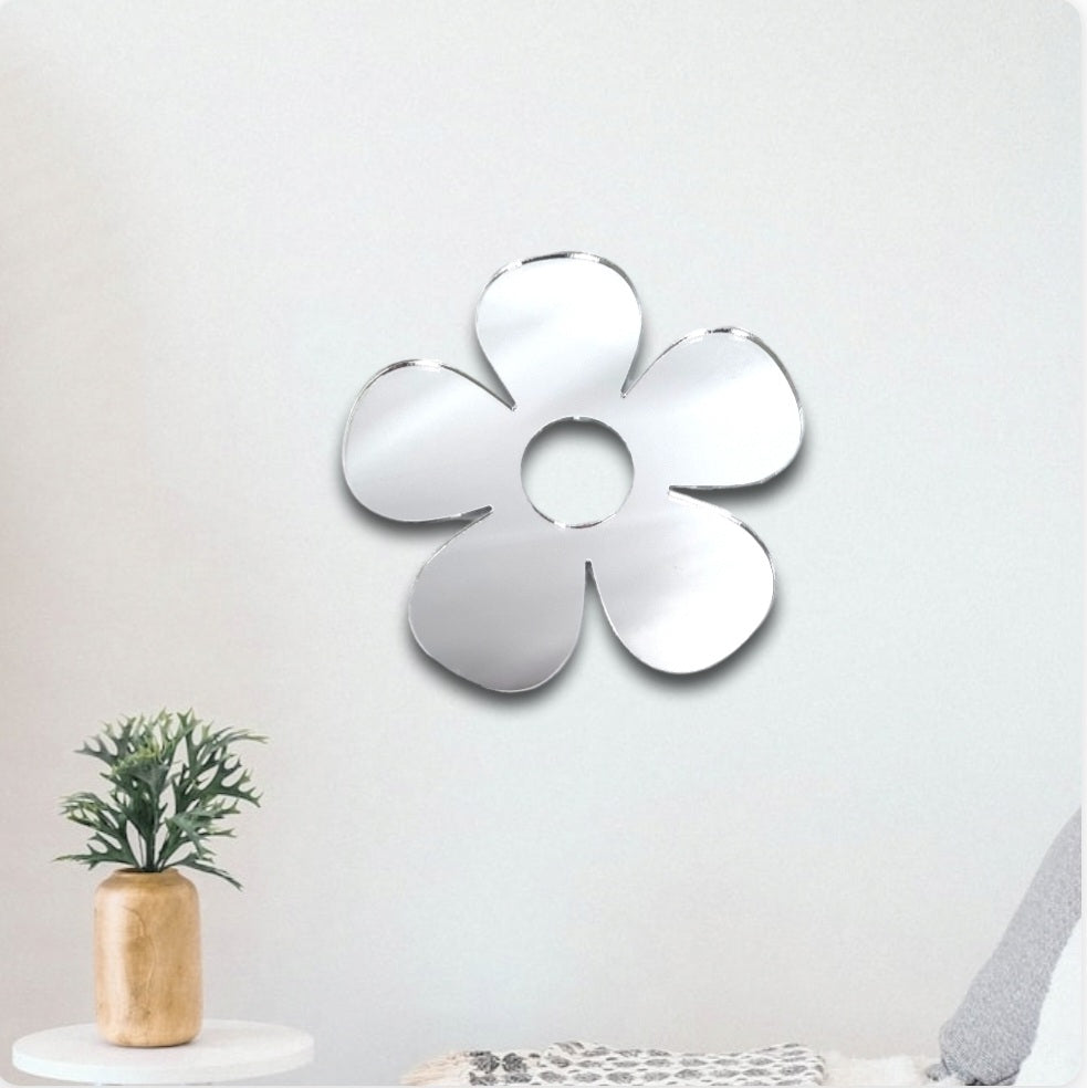 Daisy Garden Mirror in the shape of a flower with five rounded petals mounted on a white wall.