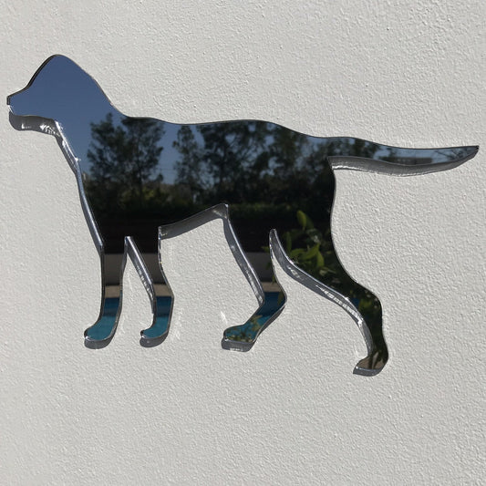 Dog-shaped reflective garden mirror mounted on a white textured wall.