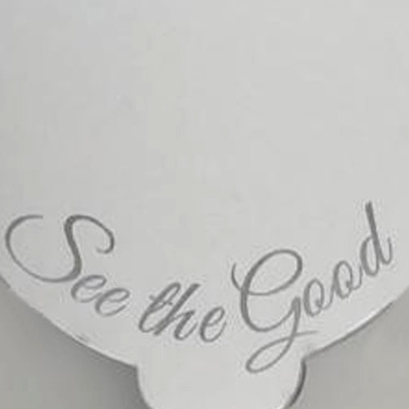 A splash-shaped handheld mirror etched with the cursive text "See the Good."