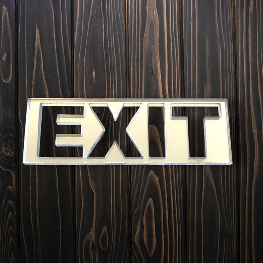 Rectangular mirrored acrylic exit sign mounted on a dark wood plank wall.