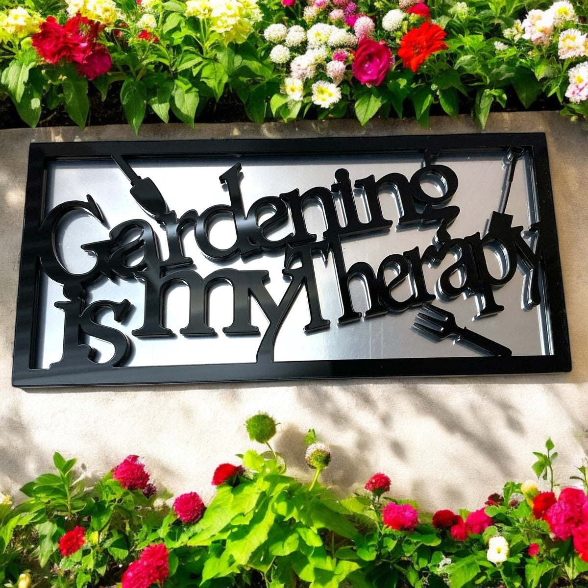 Black framed rectangular garden mirror with the black text "Gardening is my therapy" and shovel and fork graphics.
