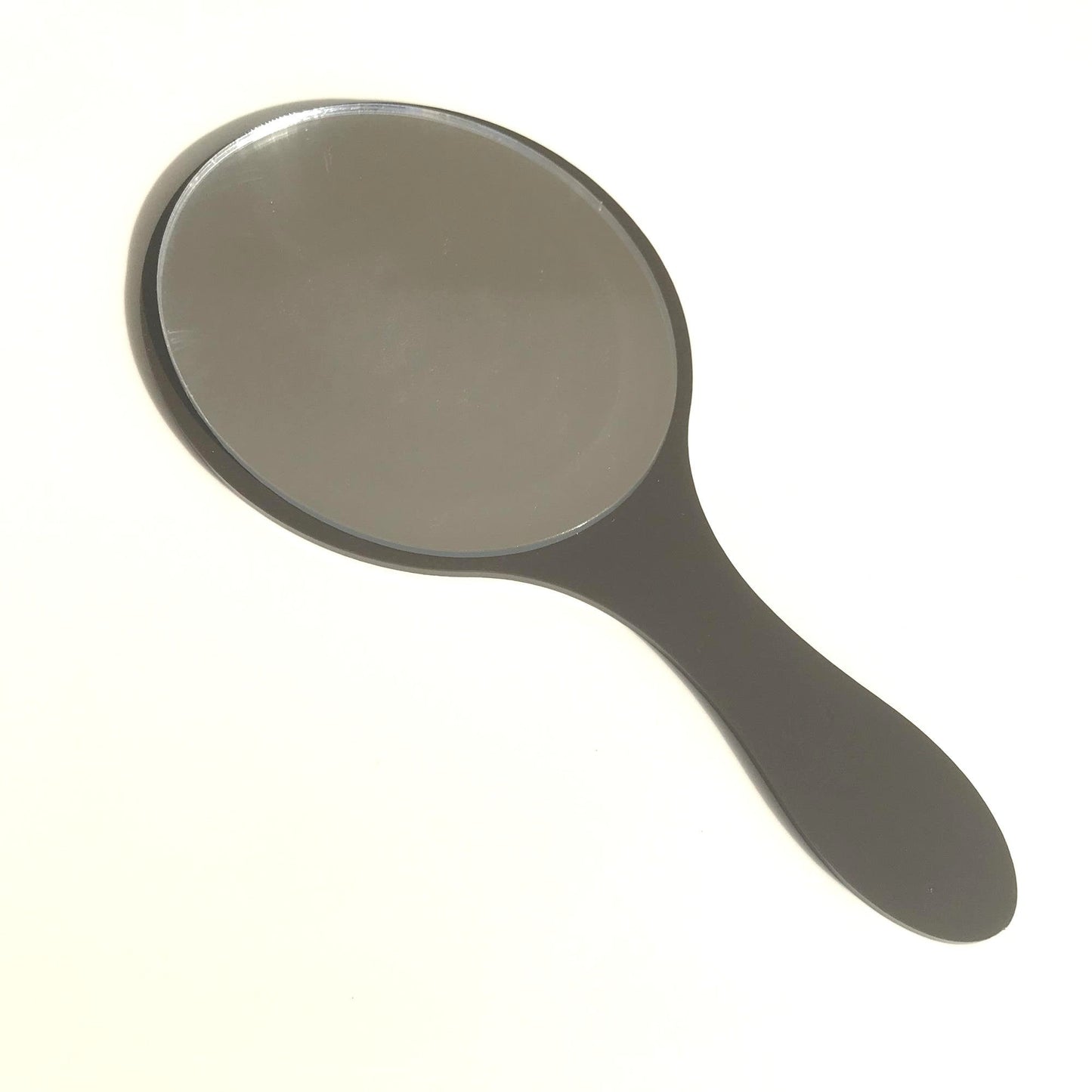 An oval hand-held mirror with a solid black handle on a white background.