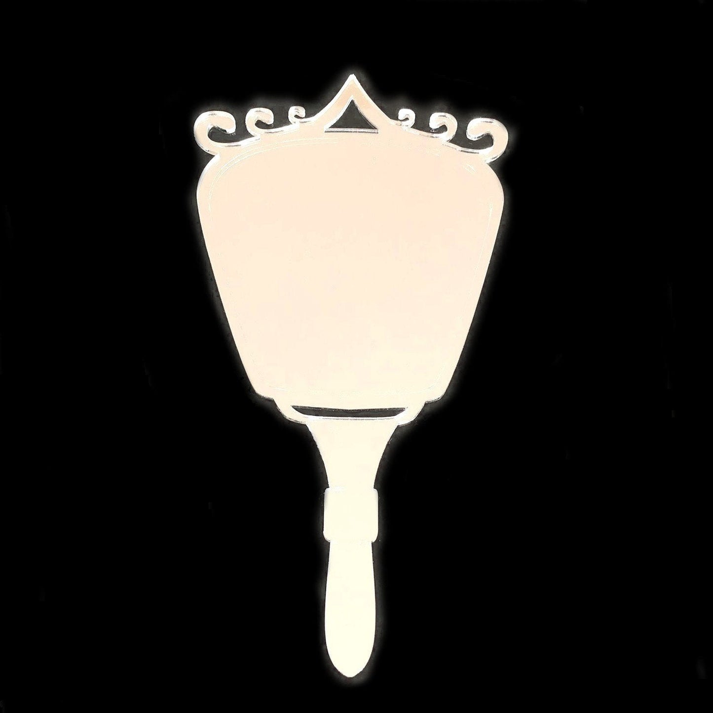 White hand-held mirror featuring an Art Deco swirl top against a black background.