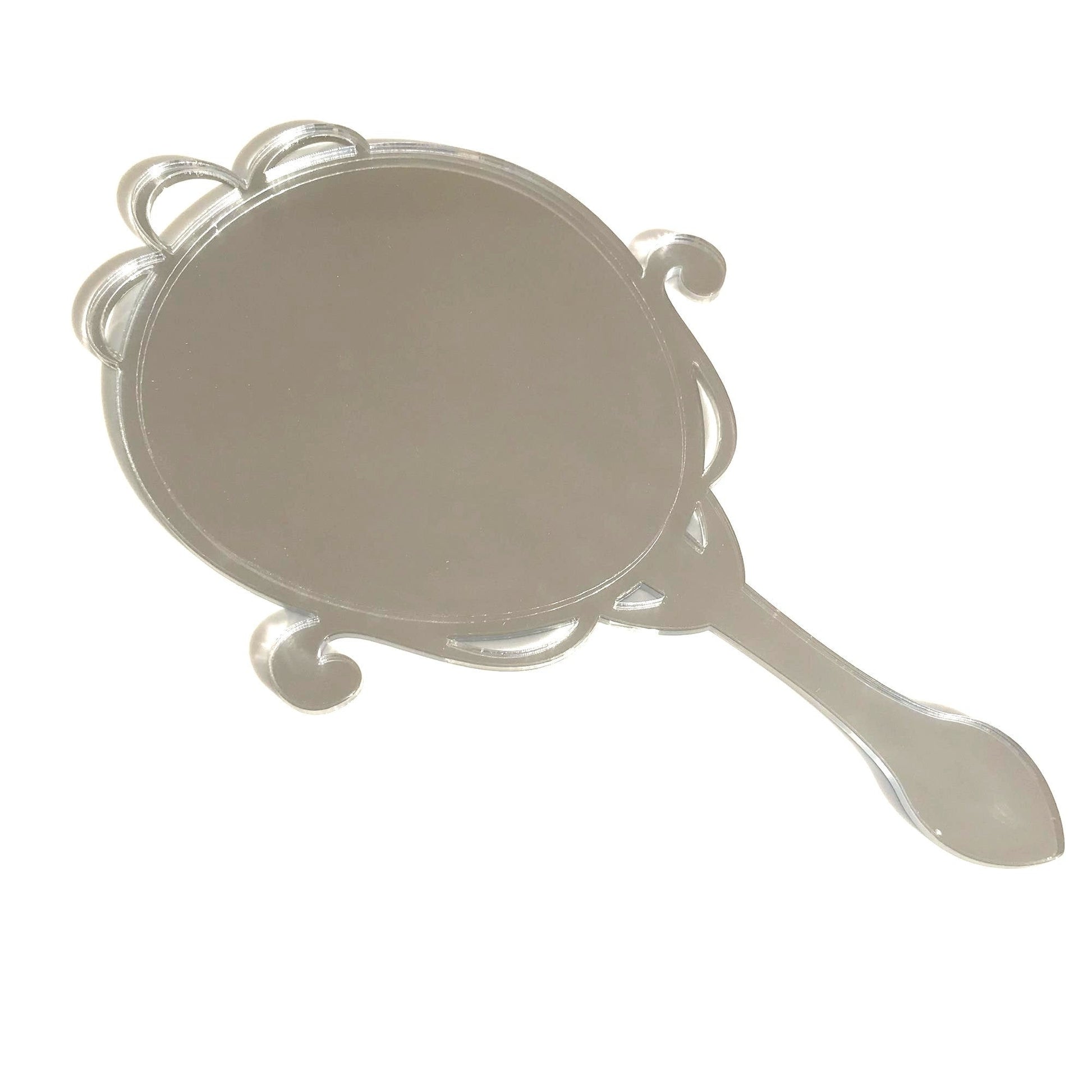 Arts and crafts style oval hand held mirror with ornate scrollwork frame, silver reflective surface.