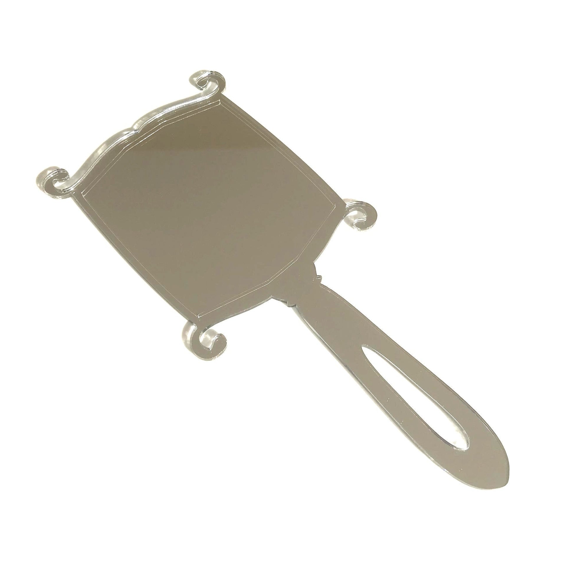 Art Deco rectangular silver hand-held mirror with ornate scrolled corners and a slotted handle.
