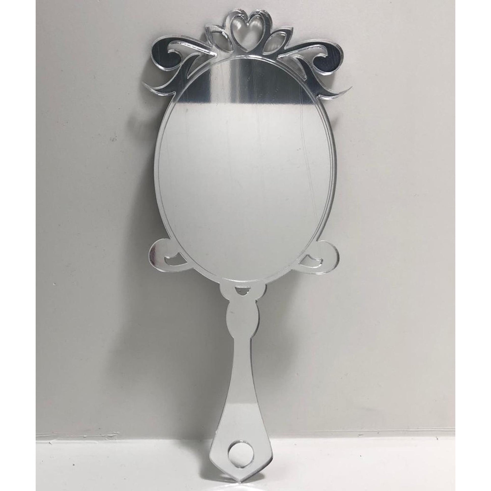 Georgian style oval hand-held mirror with ornate, mirrored scroll top and handle.