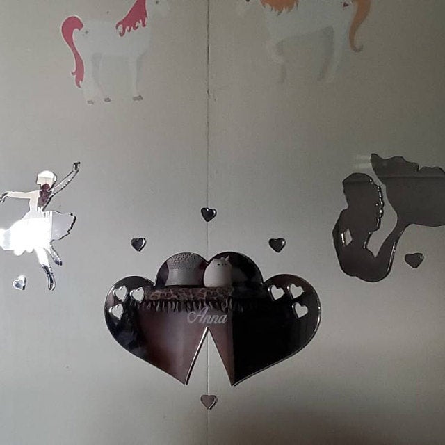 Joined hearts mirror with small heart cutouts and shelf, surrounded by decorative wall stickers.
