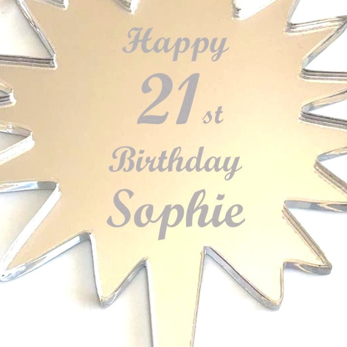 Star-shaped gold mirror cake topper engraved with "Happy 21st Birthday Sophie."