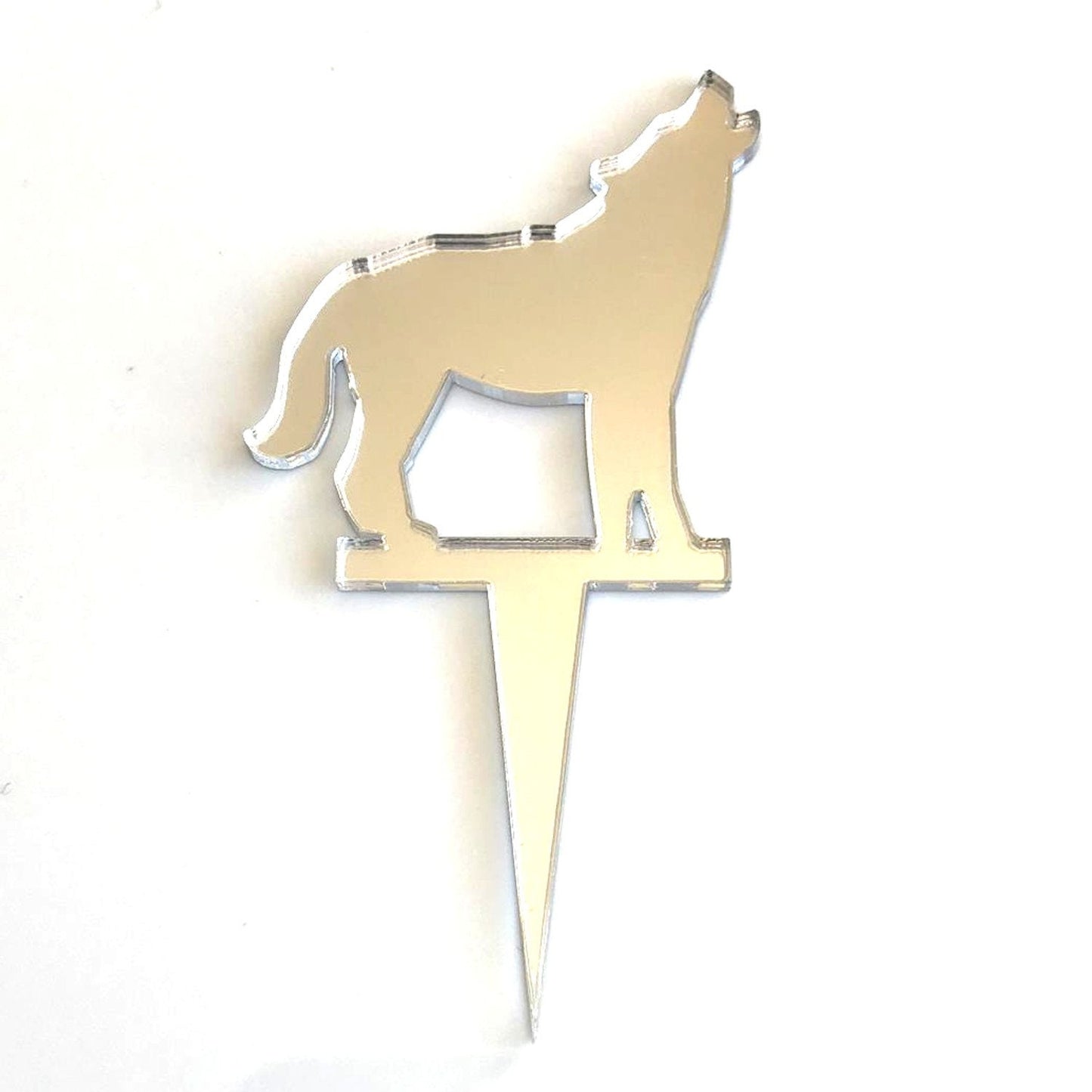 Silver mirror-finish acrylic cake topper in the shape of a howling wolf on a stake.