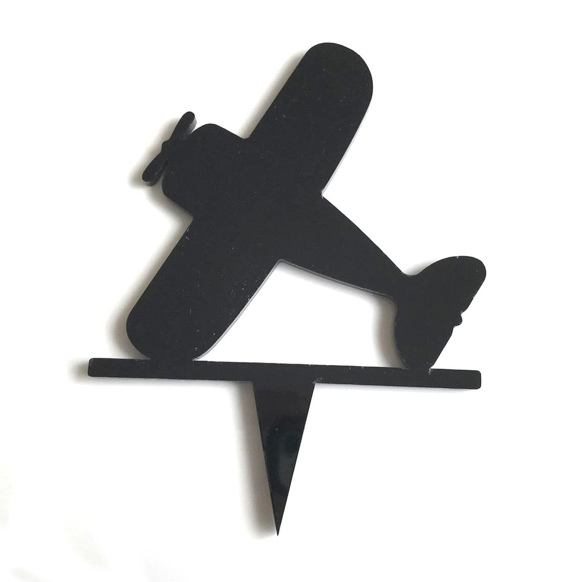 A black, glossy, bi-plane shaped acrylic cake topper with a single pointed spike base on a white background.