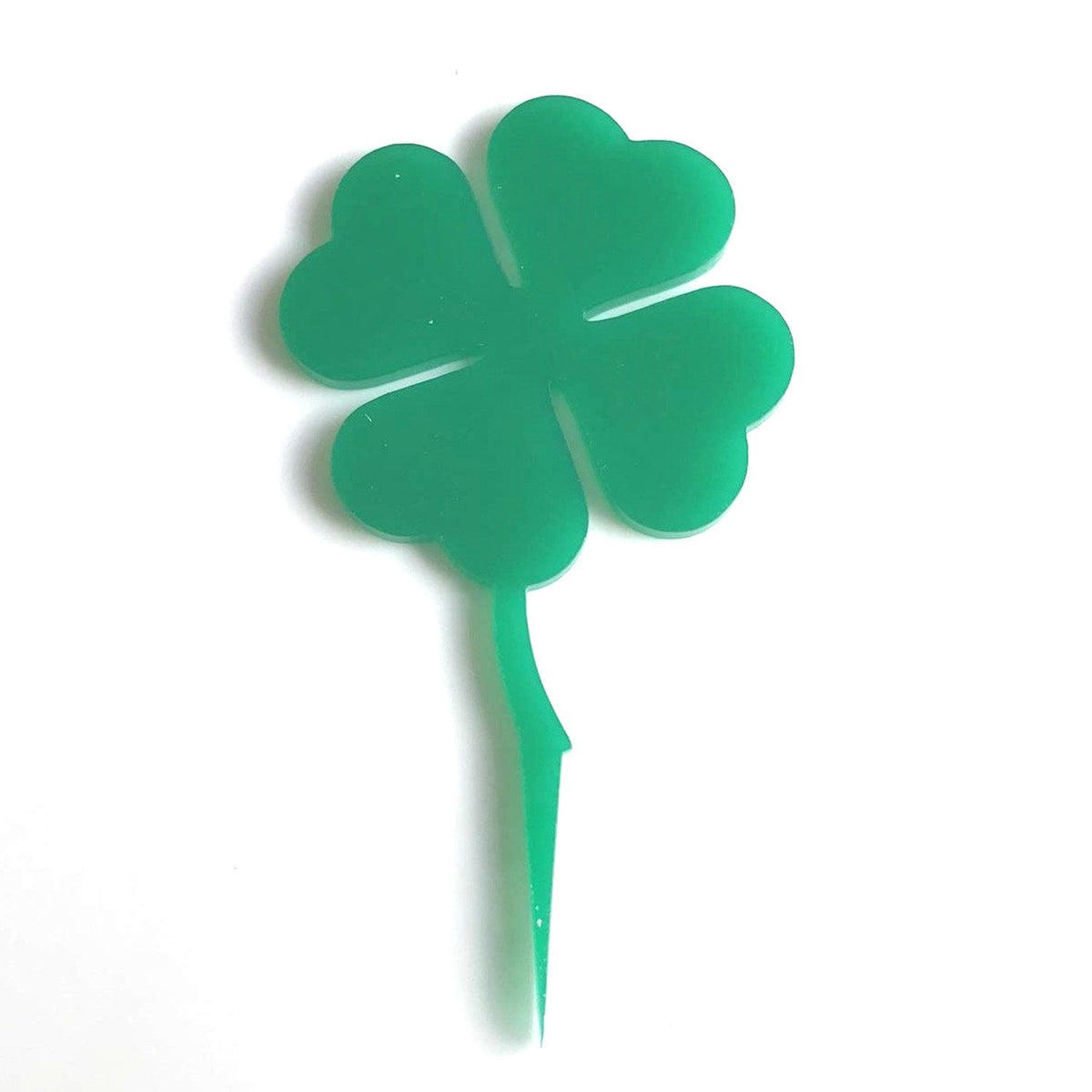 Bright green acrylic four-leaf clover cake topper with a pointed stem, isolated against a white background.