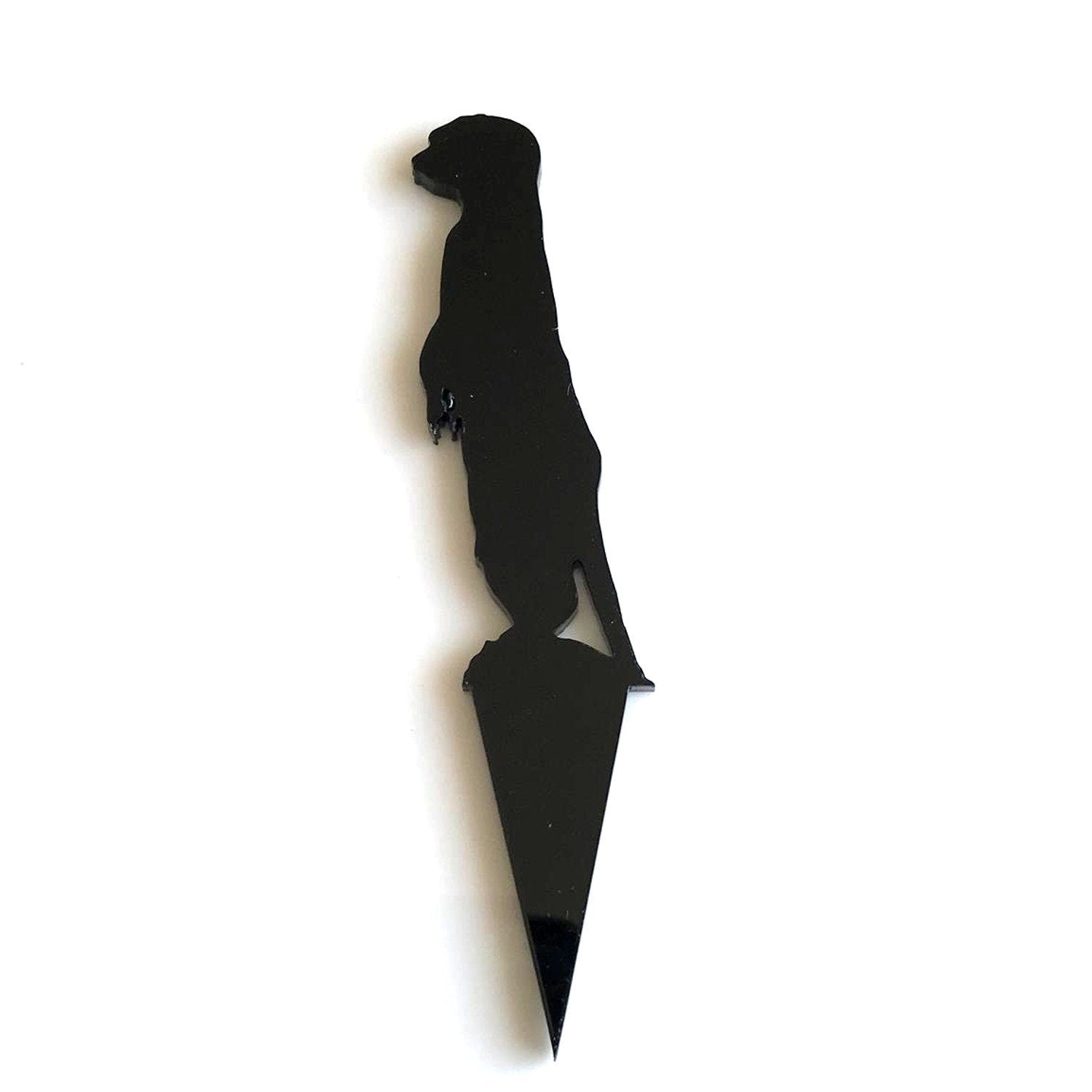 Glossy black acrylic cake topper in the silhouette shape of a standing meerkat on a pointed stake.