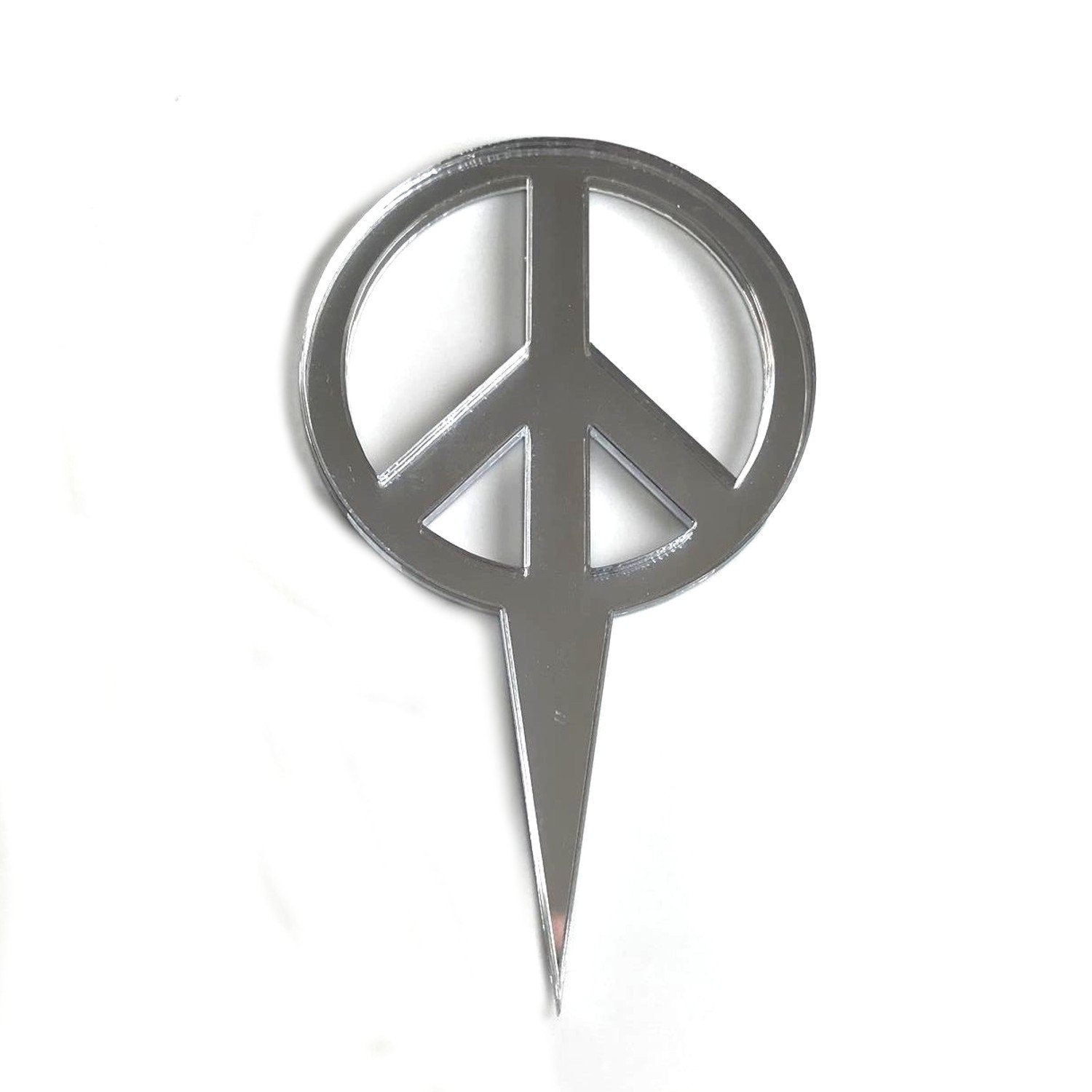 Reflective silver peace sign cake topper made of recycled acrylic, shown against a plain white background.