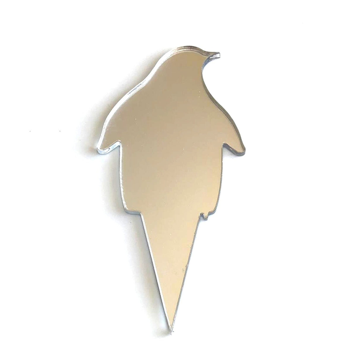 A silver mirrored, penguin-shaped cake topper with a pointed base, isolated against a white background.