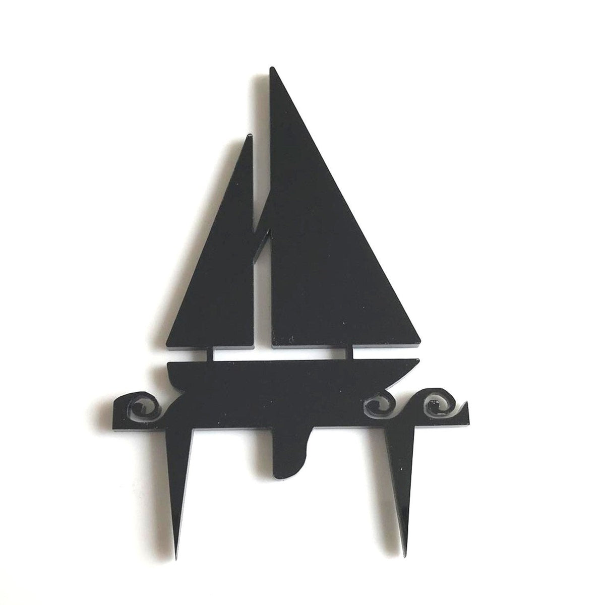 Black acrylic sailboat cake topper with stylized waves, featuring a minimalist cutout design on two pointed stems.