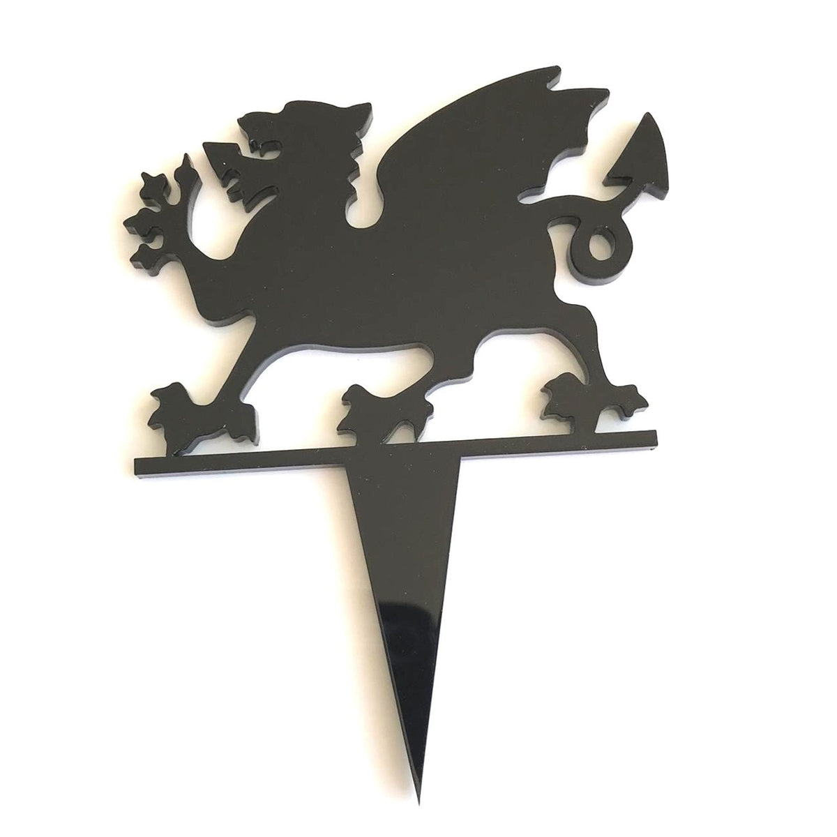 Black acrylic Welsh Dragon cupcake topper silhouette with a pointed stake base, isolated on a white background.