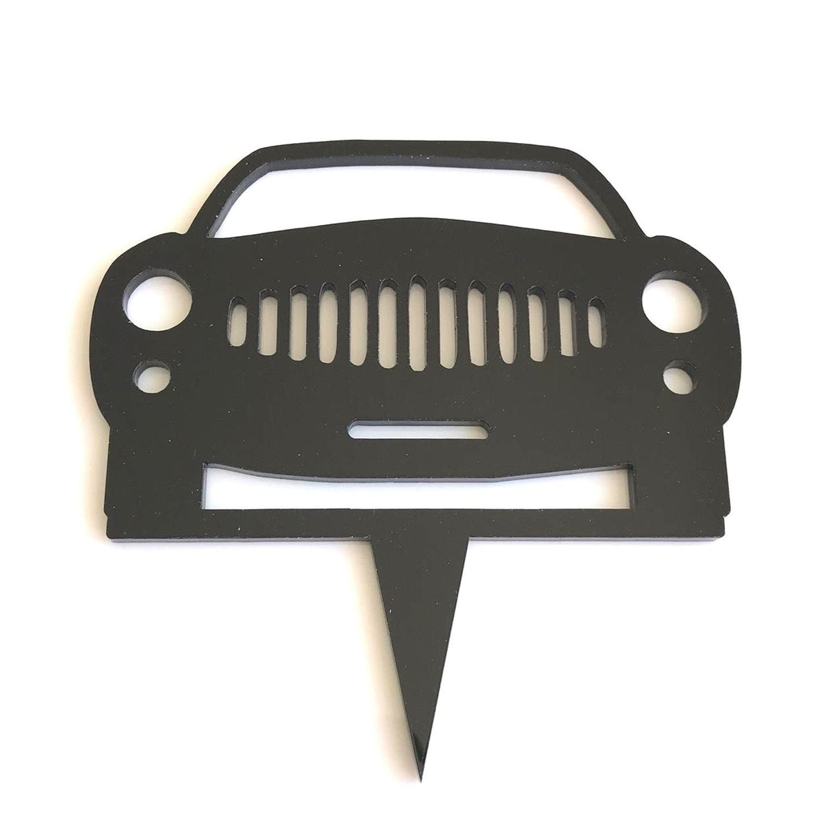 Black acrylic cake topper shaped like a minimalist front view of a car with a slotted grille.