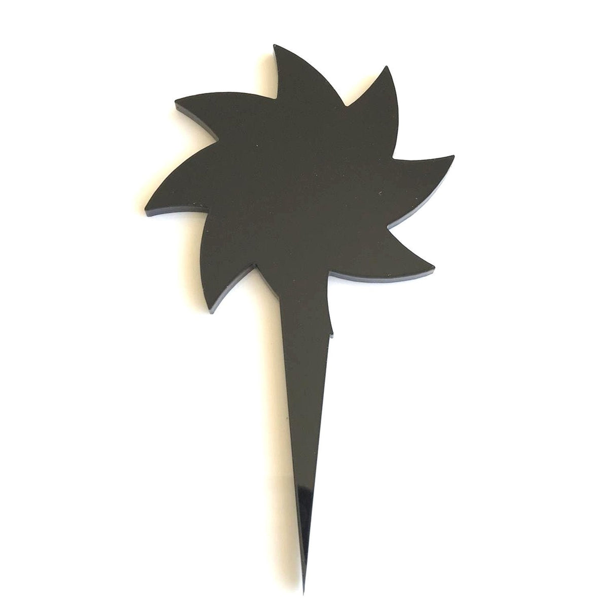 Black spiral star-shaped cake topper made from recycled acrylic, set on a pointed stake against a white background.