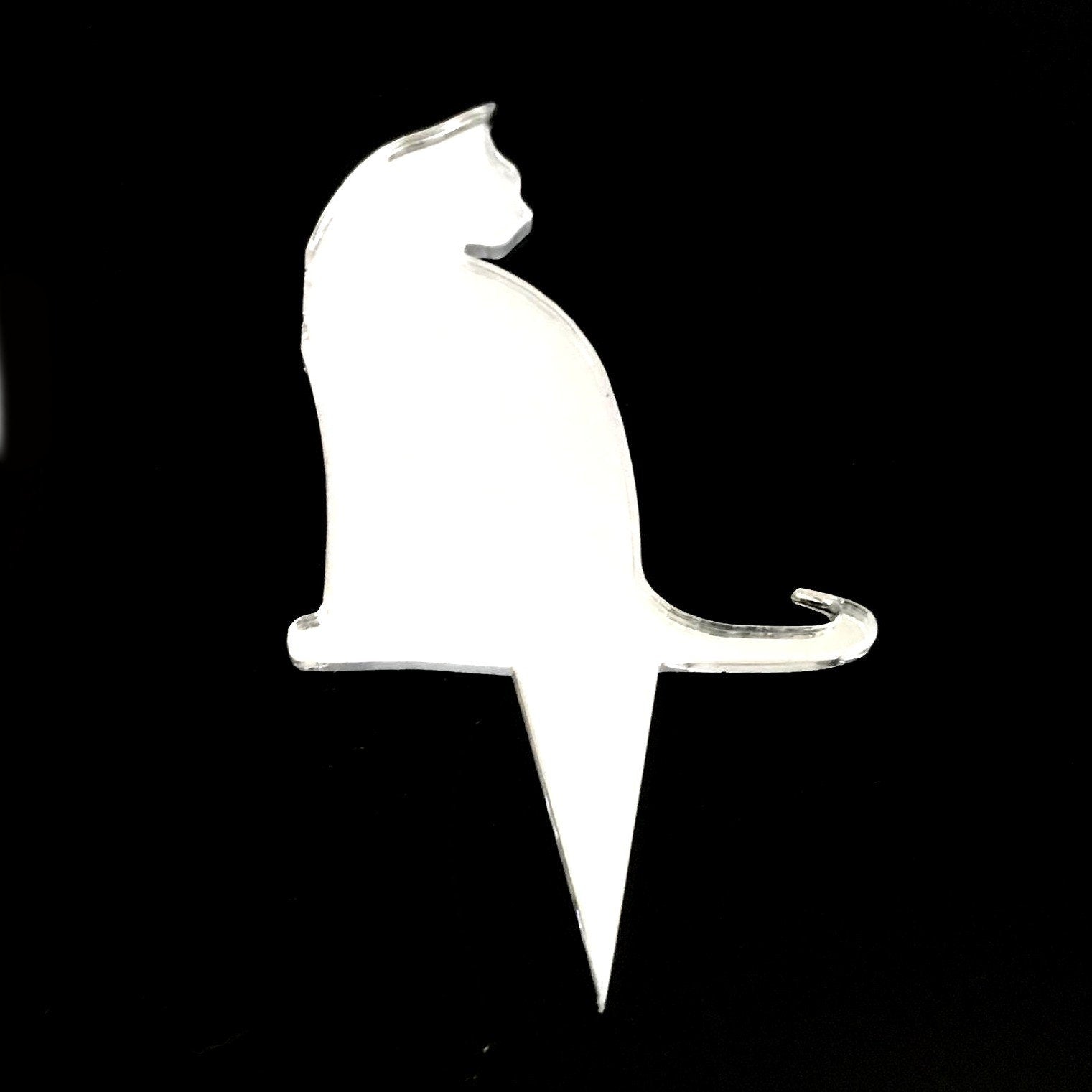Clear acrylic cat-shaped cake topper silhouette by SuperCoolCreations against a black background.