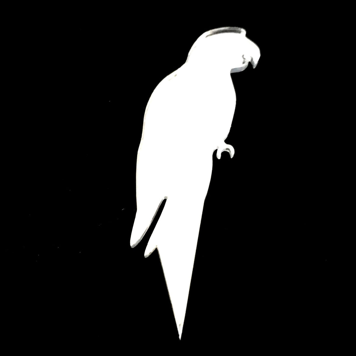 White, reflective parrot-shaped cake topper against a black background.