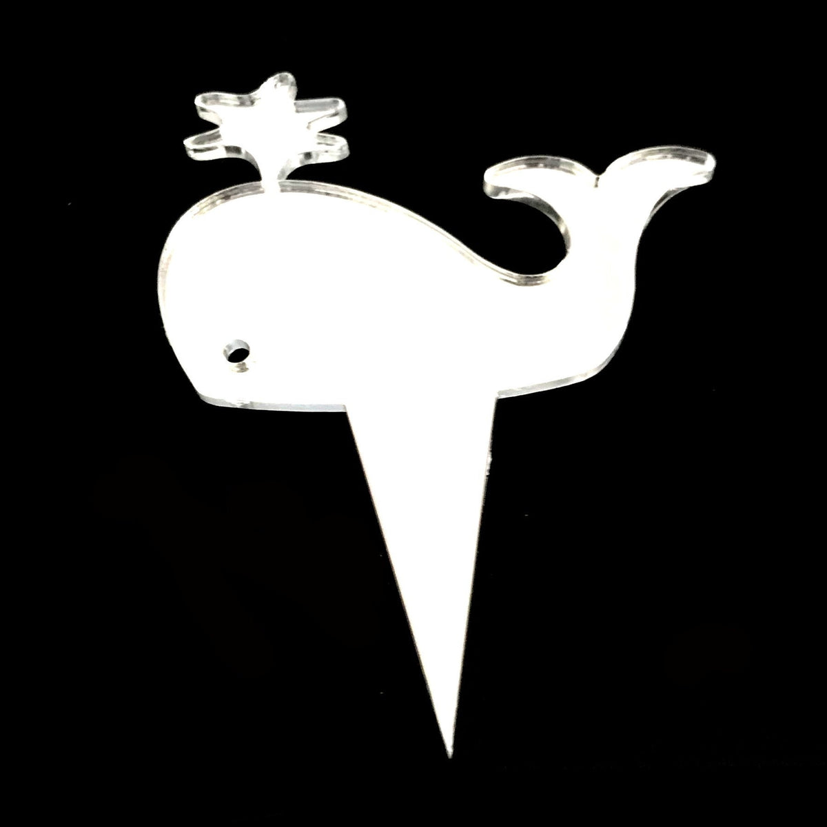 Clear acrylic whale-shaped cupcake topper with a water spout, featuring a sharp pick for inserting into cakes.