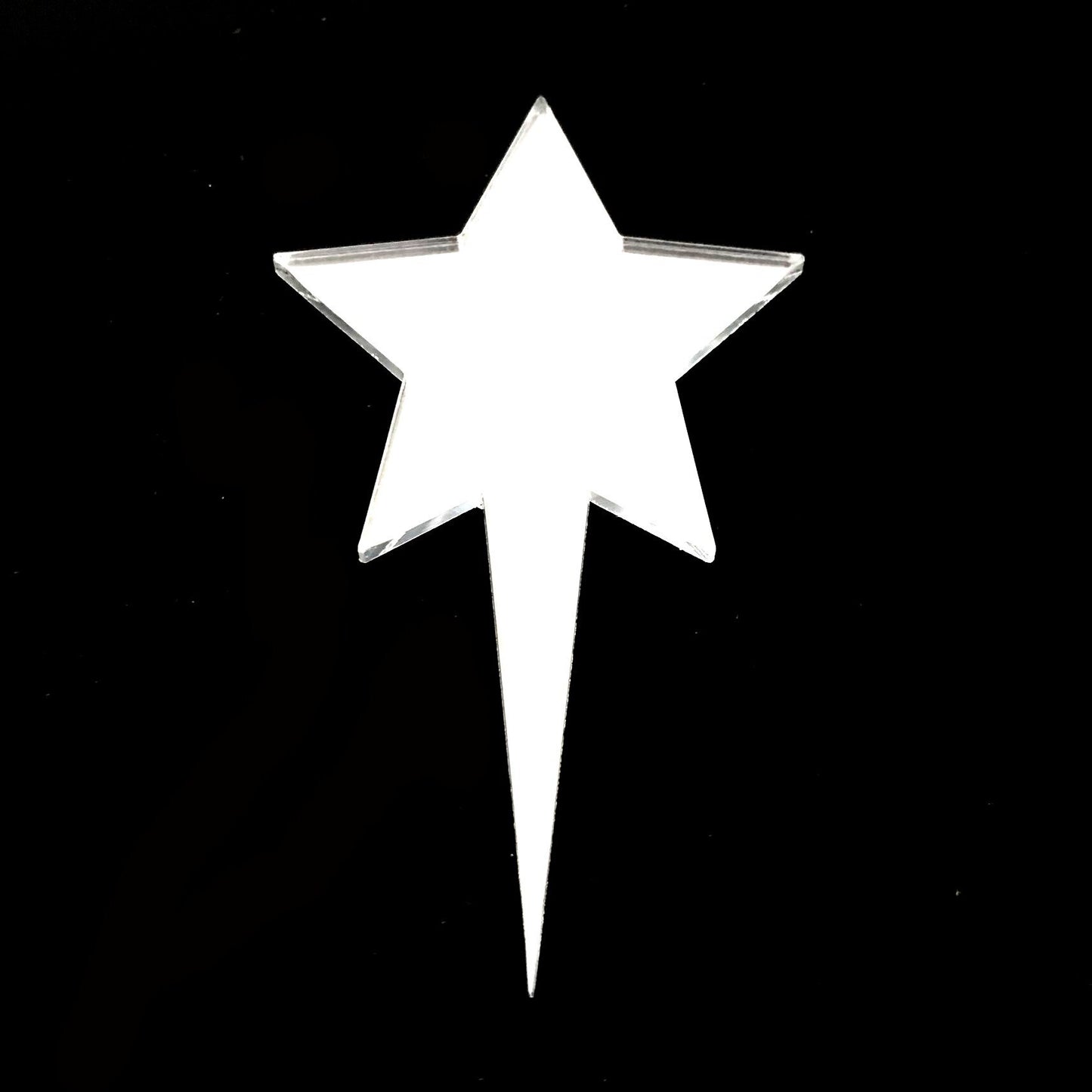 A shiny, reflective, silver-toned acrylic star cake topper with a sharp, pointed base against a black background.