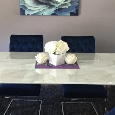 Clear, square acrylic worktop savers placed on a white marble dining table.