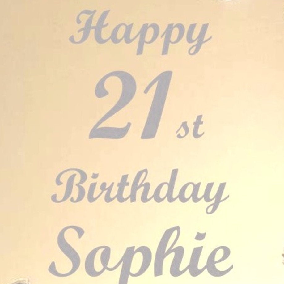 Grey cake topper text on a pale background reads: "Happy 21st Birthday Sophie" in an elegant cursive script font.