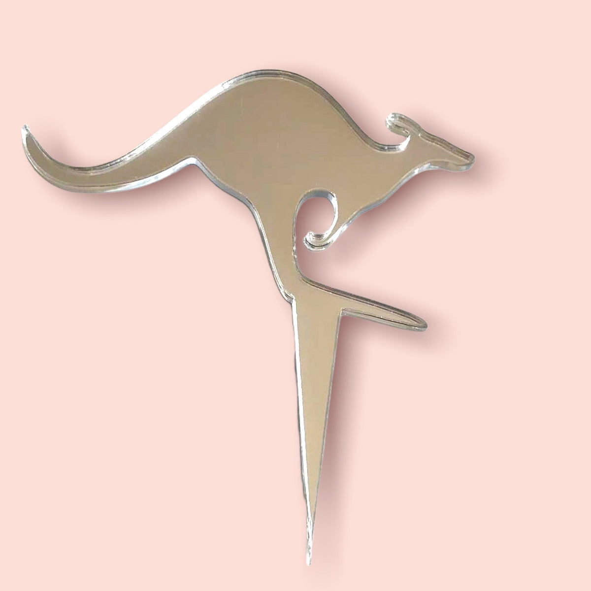 Silver mirrored acrylic cake topper in the shape of a leaping kangaroo, set against a pale pink background.
