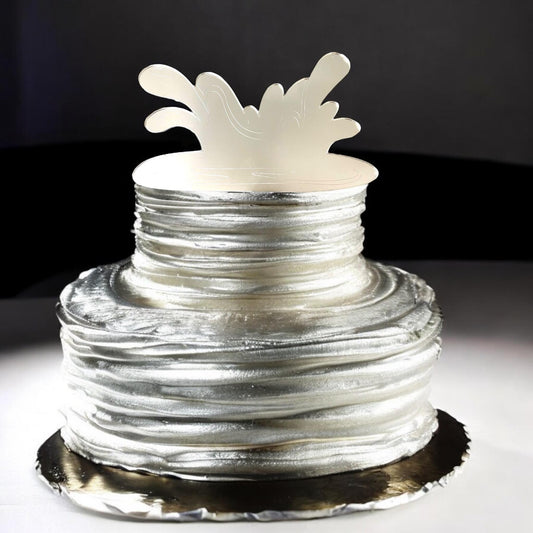 A metallic silver, wave-shaped acrylic splash cake topper sitting atop a textured, silver two-tier cake.