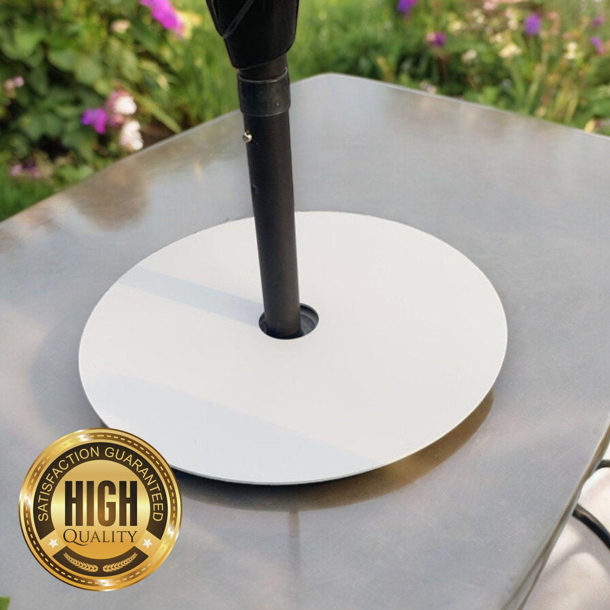 A 17-inch round, white acrylic serving mat with a center hole for a parasol pole, sitting on a garden table.