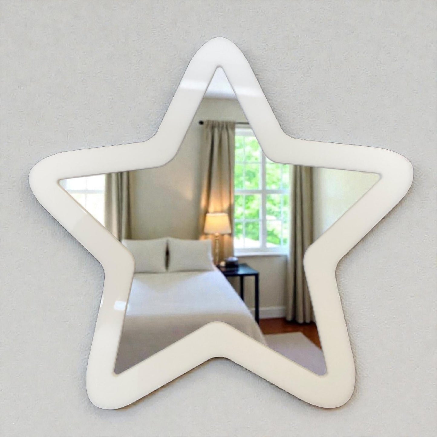 Star-shaped wall mirror with a wide white frame, mounted on a neutral wall.