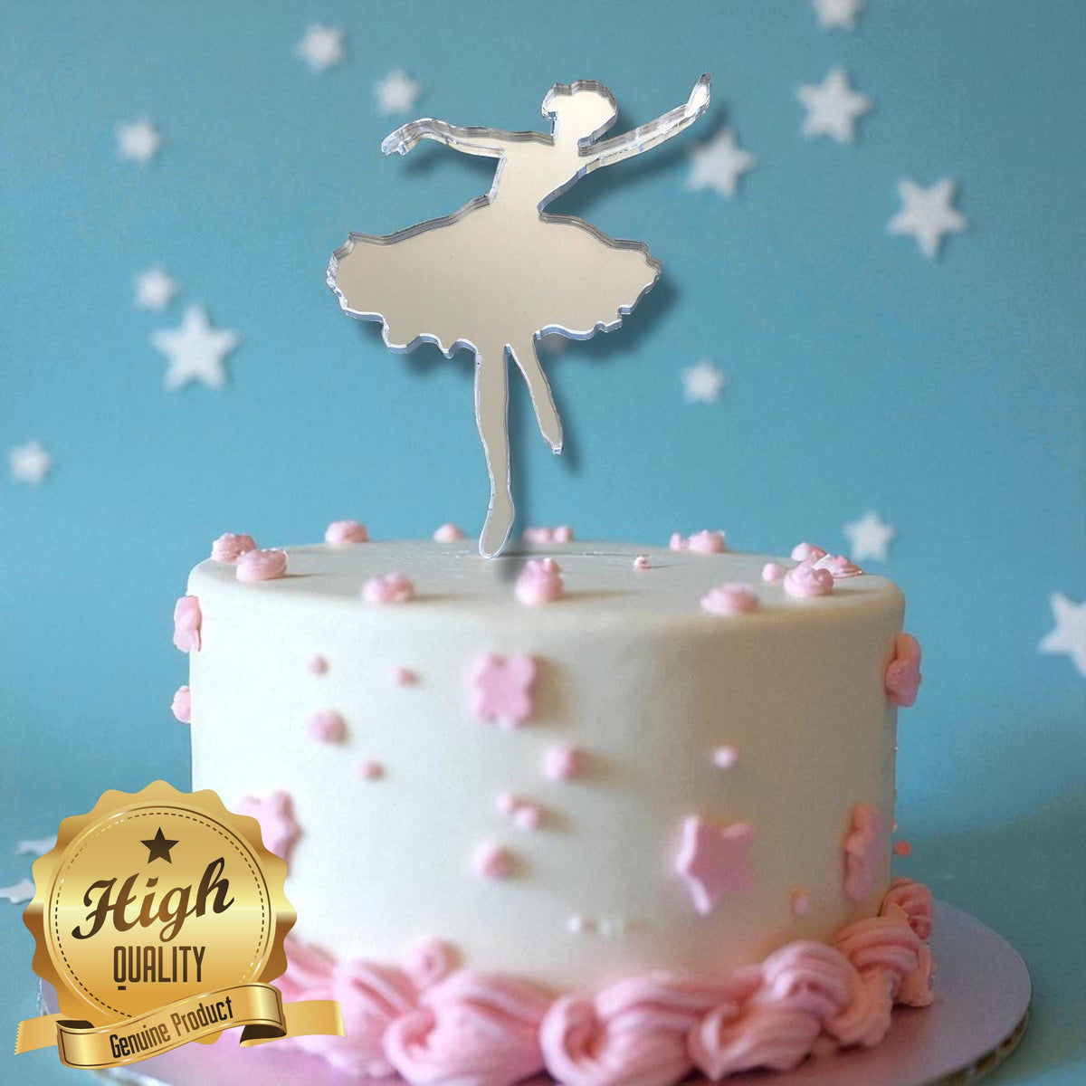 Silver mirror acrylic ballerina cake topper on a white cake with pink frosting accents and star background.