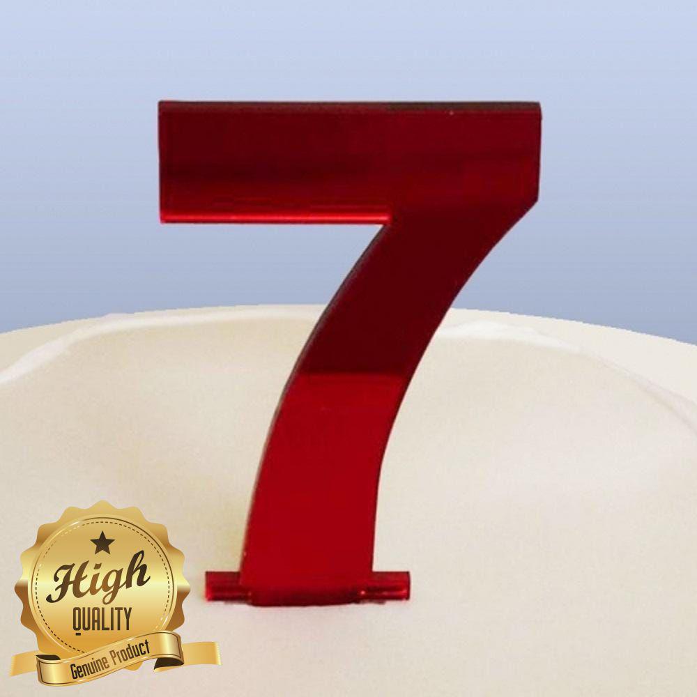 Glossy red acrylic number seven cake topper on a white surface with a gold High Quality emblem.