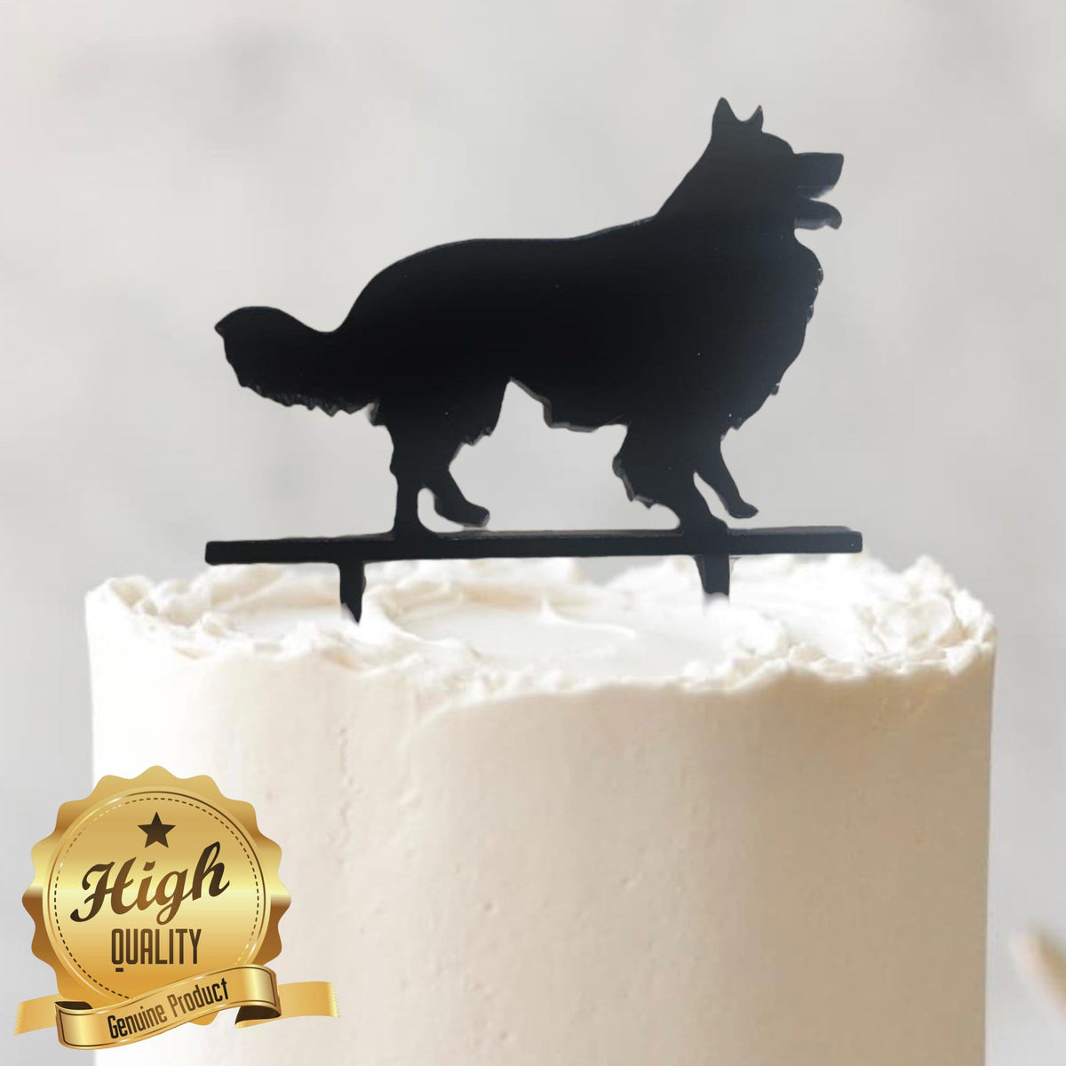 Black acrylic dog breed silhouette cake topper standing on a white frosted cake.