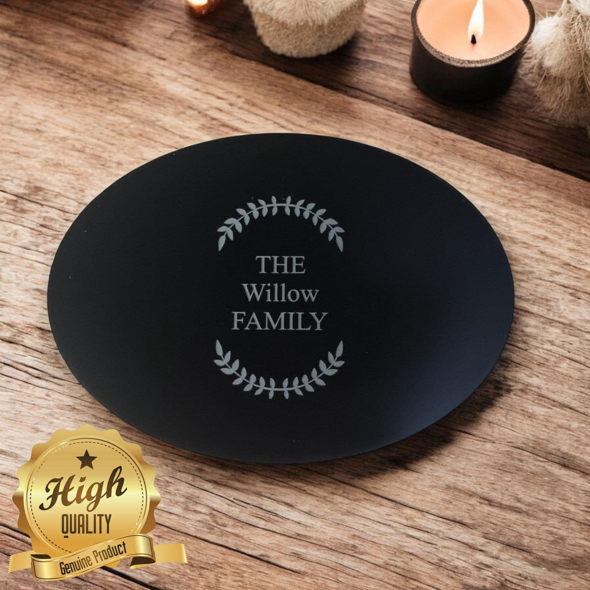Black oval acrylic worktop saver engraved with "THE Willow FAMILY" inside a leaf wreath design.