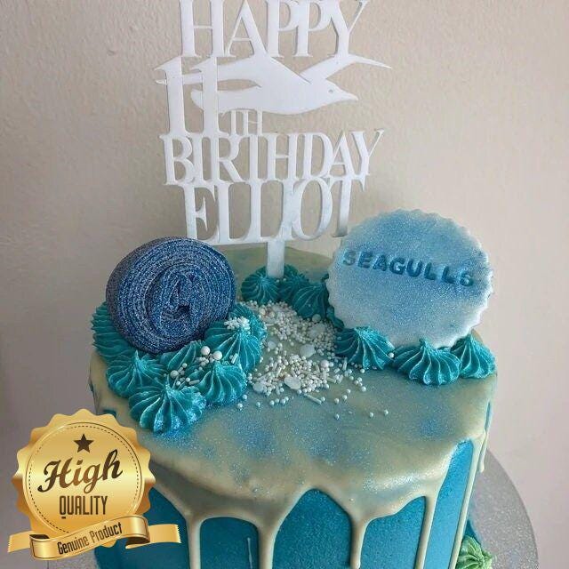 White acrylic birthday cake topper featuring a seagull silhouette and text reading "Happy 11th Birthday Elliot".