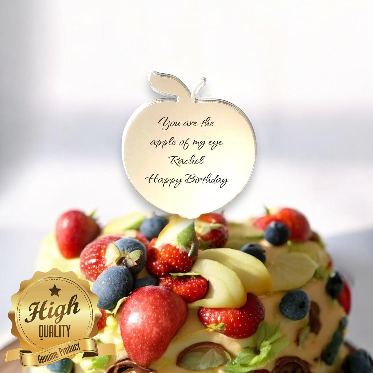 Mirror-finish apple-shaped cake topper engraved with "You are the apple of my eye, Rachel, Happy Birthday."