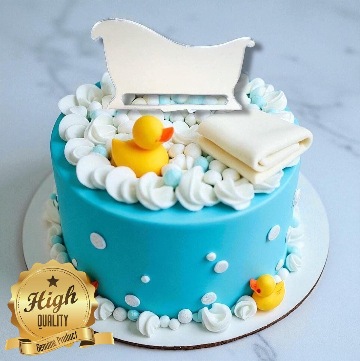 Silver mirror acrylic bathtub cake topper on a blue cake decorated with rubber duckies and frosting bubbles.